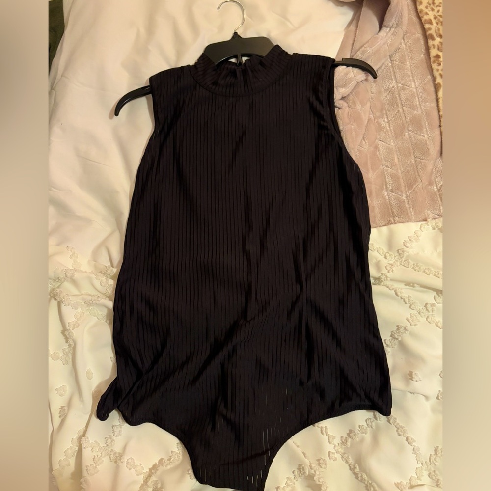 Black bodysuit. Sleeveless with button detail on back of the neck.